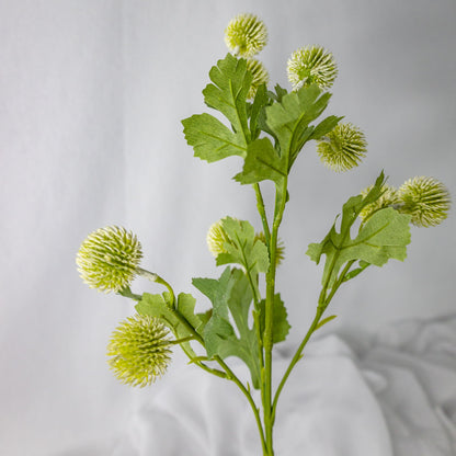 artificial white pom pom spray placed in white vase