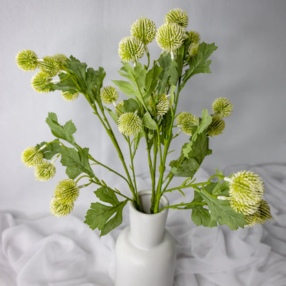 artificial white pom pom spray placed in white vase