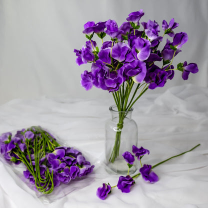 artificial Mauve Sweet Pea flowers in glass vase