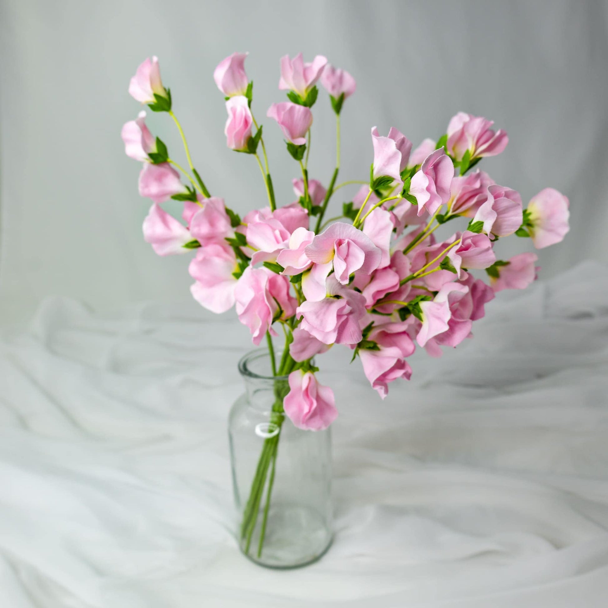 artificial Pink Sweet Peas in clear glass vase