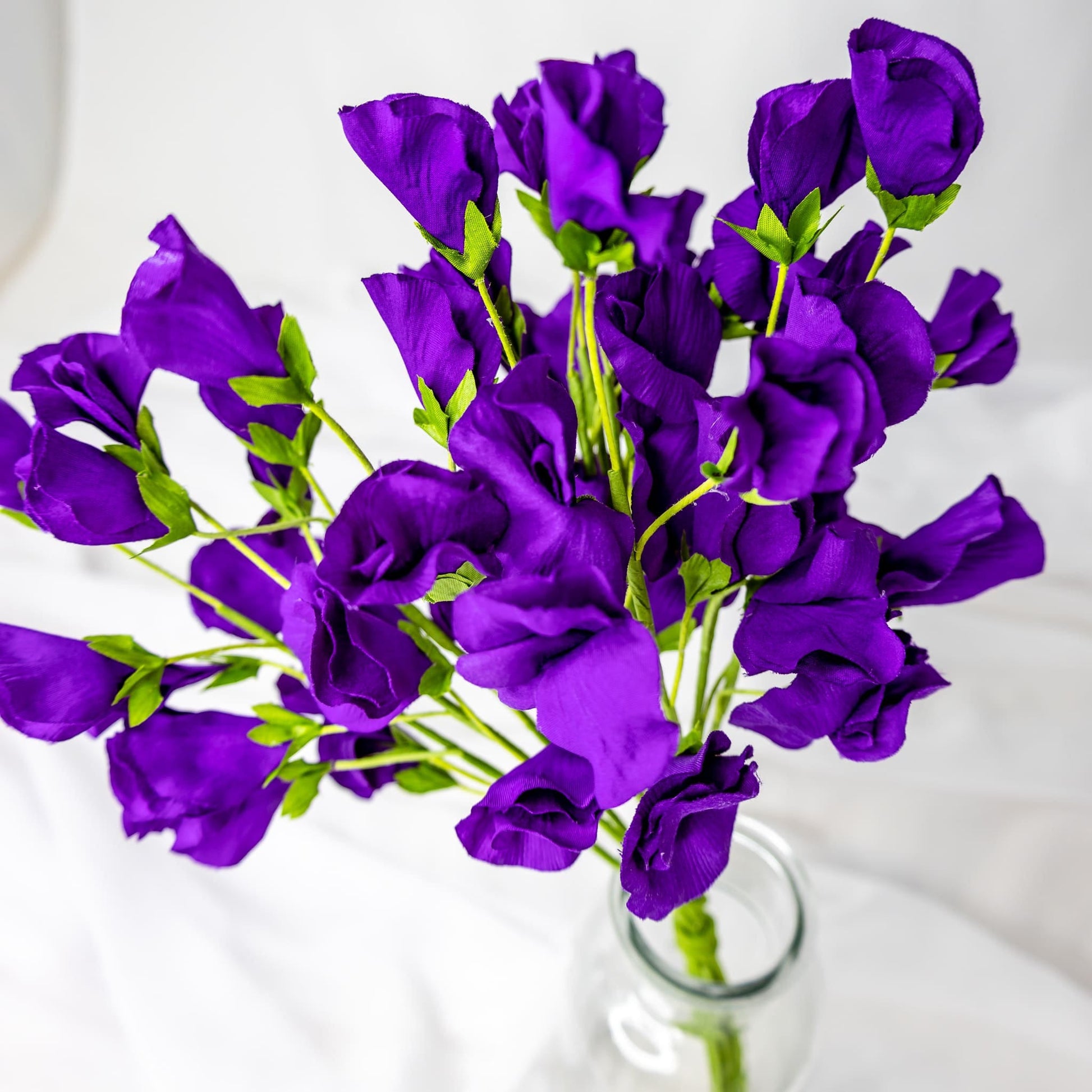 artificial Purple Sweet Pea in clear glass vase top view