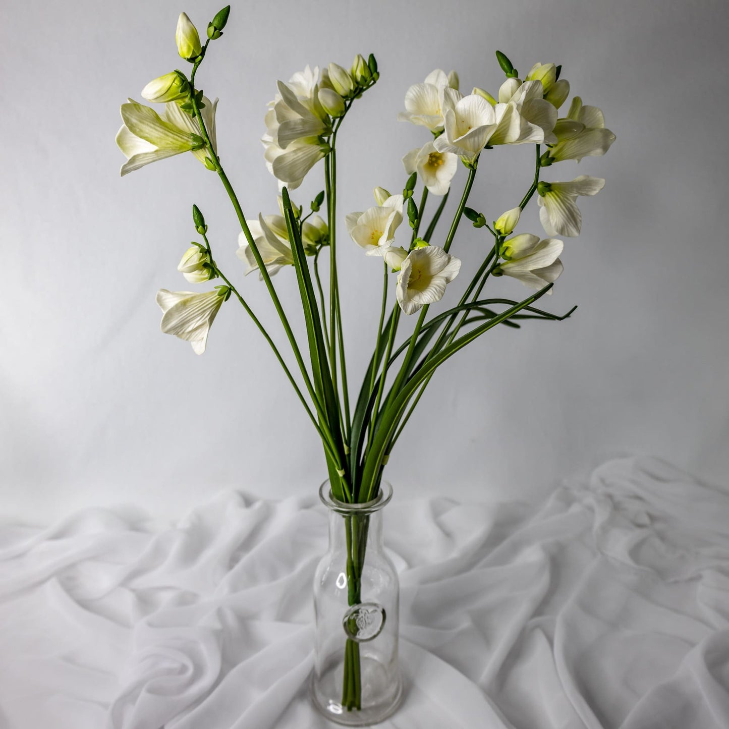 artificial Freesia in glass vase