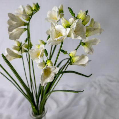 artificial Freesia in glass vase top view