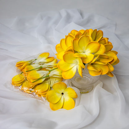 artificial tahitian gold frangipani flowers placed in transparent glass vase