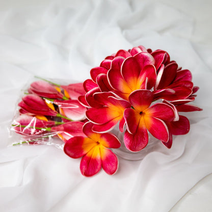 artificial passion frangipani flowers placed in transparent glass vase