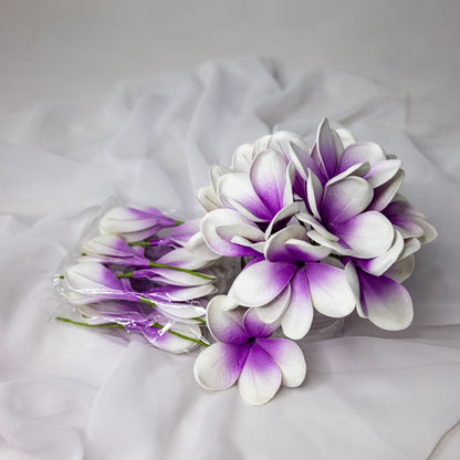 artificial picasso frangipani flowers placed in transparent glass vase