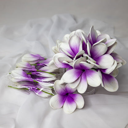 artificial picasso frangipani flowers placed in transparent glass vase