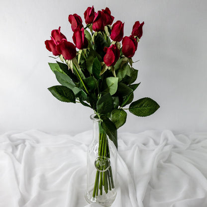 artificial red rose buds placed in transparent glass vase