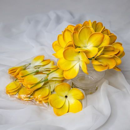 artificial tahitian gold frangipani flowers placed in transparent glass vase