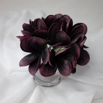 artificial midnight frangipani flowers placed in glass vase