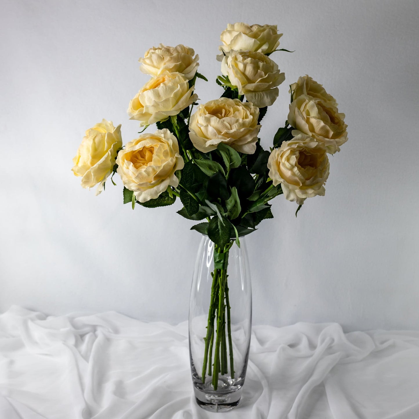 artificial pale peach david austin roses placed in transparent glass vase